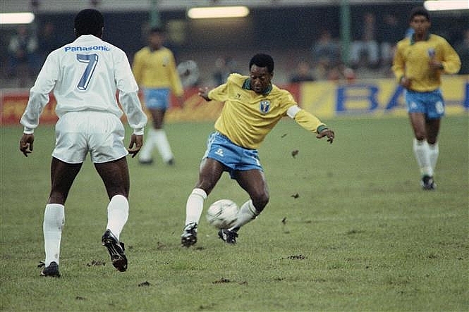  Huyền thoại bóng đá Brazil Pele (trái) đi bóng trong trận đấu giao hữu của đội tuyển các ngôi sao bóng đá thế giới với tuyển Brazil nhân ngày sinh nhật thứ 50 của ông ở Milan (Italy) ngày 31/10/1990. Ảnh: AFP/TTXVN