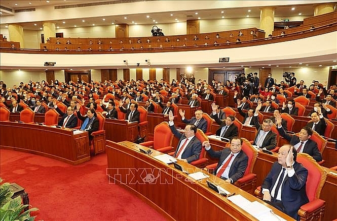 Các đồng chí lãnh đạo Đảng, Nhà nước và các đại biểu biểu quyết thông qua chương trình Hội nghị. Ảnh: Trí Dũng/TTXVN