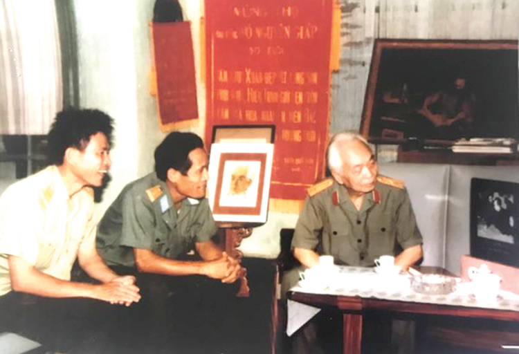 Đại Tướng V&otilde; Nguy&ecirc;n Gi&aacute;p c&ugrave;ng đồng ch&iacute; Đinh Kh&ocirc;i Sỹ v&agrave; Trần Th&agrave;nh hai c&aacute;n bộ viết sử của Qu&acirc;n chủng Ph&ograve;ng Kh&ocirc;ng xem bức tranh đ&aacute;