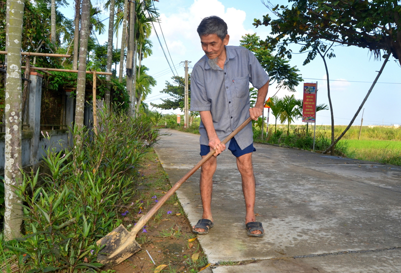 Cụ Lai chăm s&oacute;c &ldquo;đường hoa&rdquo; xanh-sạch- đẹp&rdquo;.