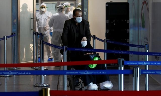 H&agrave;nh kh&aacute;ch đi từ Iran đến s&acirc;n bay Najaf ở Iraq ng&agrave;y 5/3. Ảnh: Reuters.