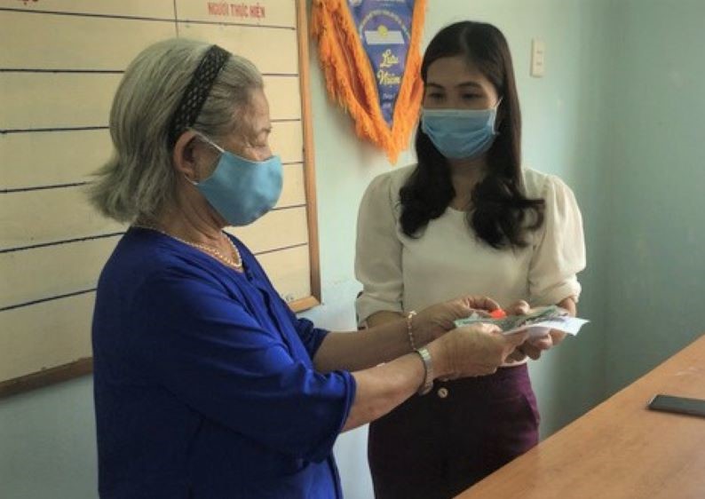 Cụ Đ&agrave;o Thị Hu&ecirc; ở Quảng Ng&atilde;i trao tiền v&agrave; v&agrave;ng ủng hộ chống dịch Covid-19. Ảnh IT
