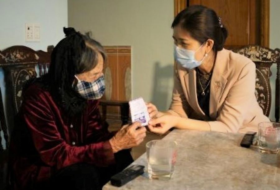 Mẹ liệt sĩ Vũ Thị Th&acirc;n trao tiền ủng hộ địa phương chống dịch. Ảnh IT