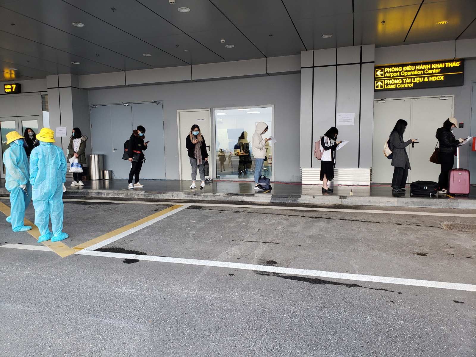 H&agrave;nh kh&aacute;ch xếp h&agrave;ng l&agrave;m thủ tục đảm bảo khoảng c&aacute;ch 2m