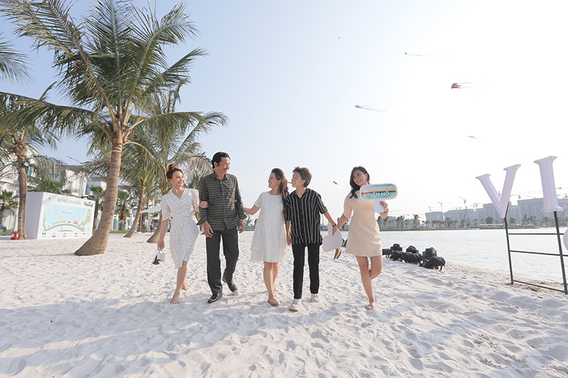 Bốn bố con &ocirc;ng Sơn đi dạo b&ecirc;n b&atilde;i c&aacute;t rộng 35m của hồ nước ngọt nh&acirc;n tạo lớn nhất nằm trong l&ograve;ng một dự &aacute;n bất động sản tại Việt Nam. Với b&atilde;i c&aacute;t trắng trải d&agrave;i v&agrave; h&agrave;ng dừa xanh t&iacute;t tắp khiến nhiều người nhầm tưởng d&agrave;n diễn vi&ecirc;n đang đi tr&ecirc;n b&atilde;i biển.