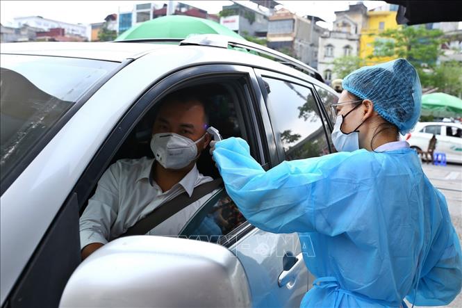 Nh&acirc;n vi&ecirc;n y tế kiểm tra th&acirc;n nhiệt đối với người v&agrave;o bệnh viện (ảnh chụp s&aacute;ng 11/5).