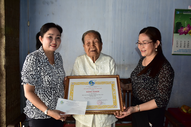 B&agrave; Trần Thị Lan Phương, Chủ tịch Hội LHPN tỉnh Bạc Li&ecirc;u (b&igrave;a tr&aacute;i) thừa ủy quyền của Chủ tịch Hội LHPN Việt Nam tặng bằng khen cho cụ b&agrave; Trần Thị L&eacute;n