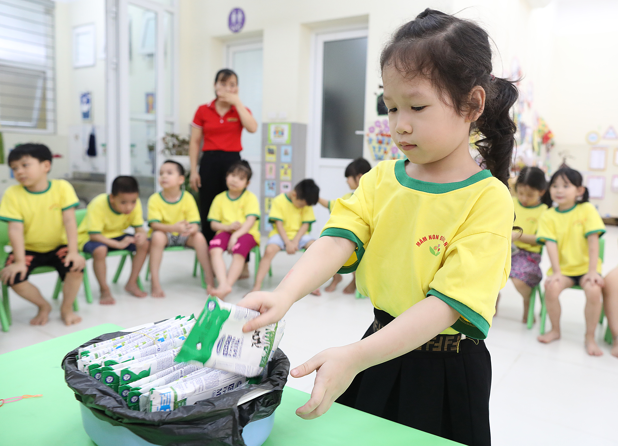 C&aacute;c em học sinh được hướng dẫn c&aacute;ch gấp gọn v&agrave; thu dọn hộp sữa sau khi sử dụng xong