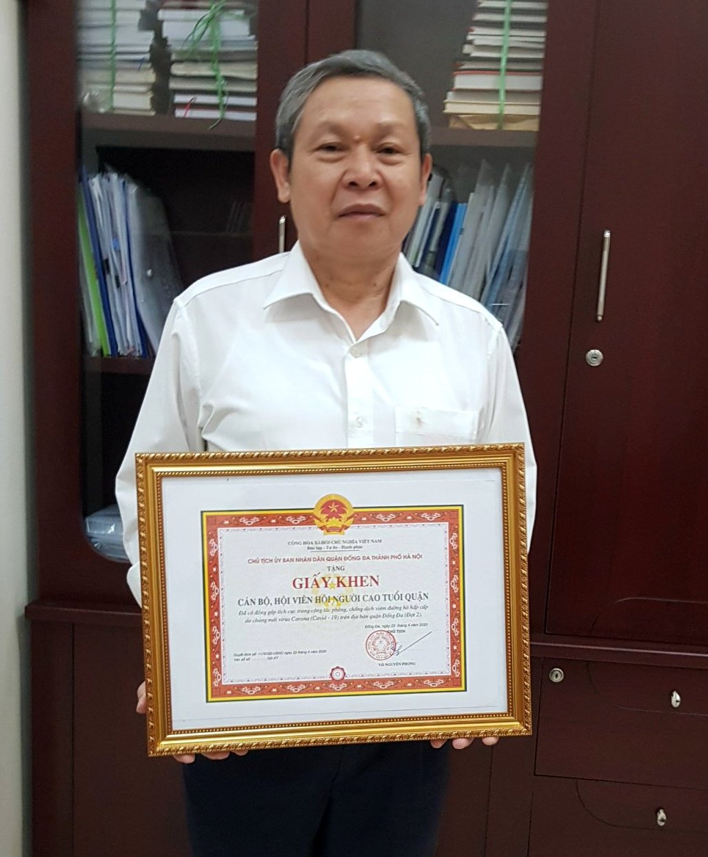 &Ocirc;ng B&ugrave;i Long H&ograve;a, Trưởng BĐD quận thay mặt c&aacute;n bộ, hội vi&ecirc;n đ&oacute;n nhận Giấy khen của Chủ tịch UBND quận