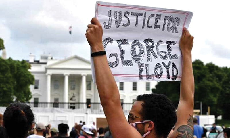 Một người biểu t&igrave;nh giơ tờ giấy c&oacute; d&ograve;ng chữ "c&ocirc;ng l&iacute; cho George Floyd" b&ecirc;n ngo&agrave;i Nh&agrave; Trắng h&ocirc;m 29/5.      Ảnh: AFP