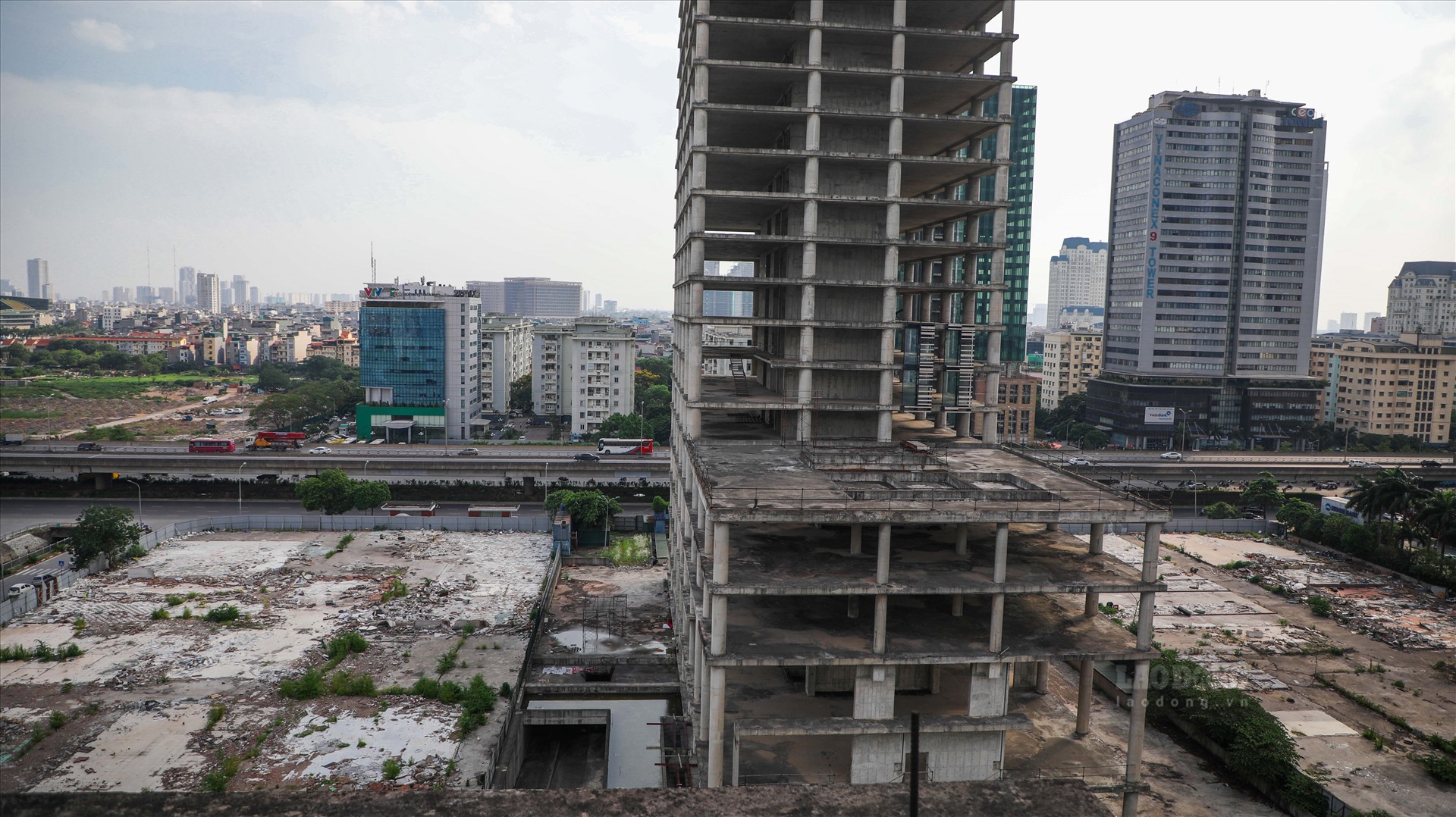 Theo ghi nhận của PV, đến nay t&ograve;a th&aacute;p n&agrave;y chỉ mới ho&agrave;n thiện phần th&ocirc;, c&ocirc;ng trường kh&ocirc;ng c&oacute; bất kỳ hoạt động x&acirc;y dựng n&agrave;o, cỏ hoang mọc ở nhiều nơi, h&agrave;ng r&agrave;o bao quanh đ&atilde; xuống cấp.