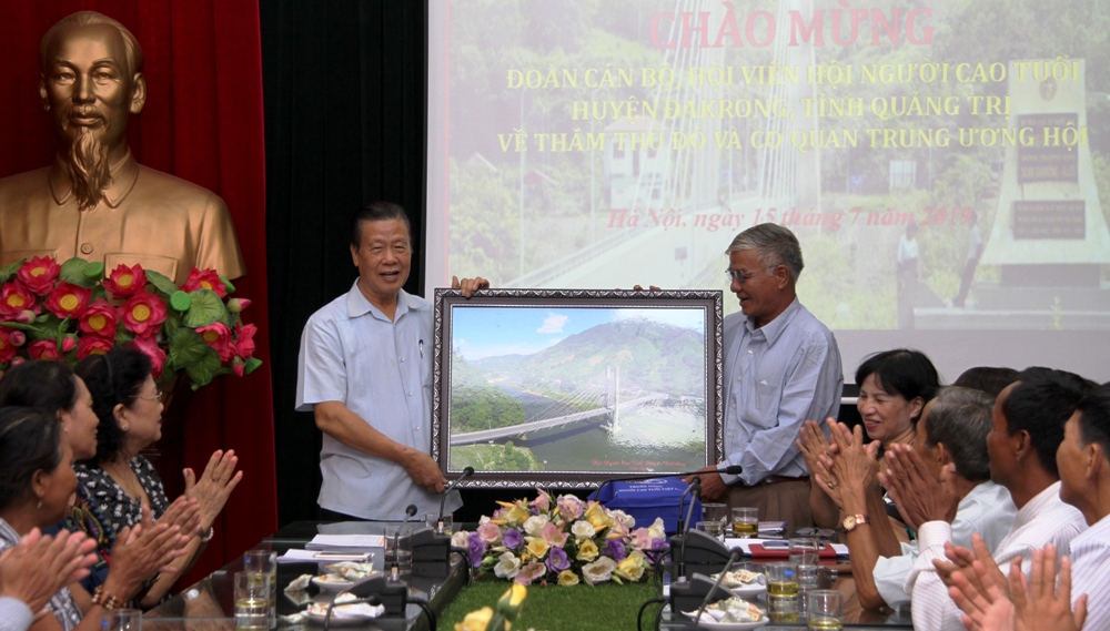 &Ocirc;ng Nguyễn Ngọc Thản thay mặt đo&agrave;n tặng TW Hội bức tranh cầu Thạch H&atilde;n