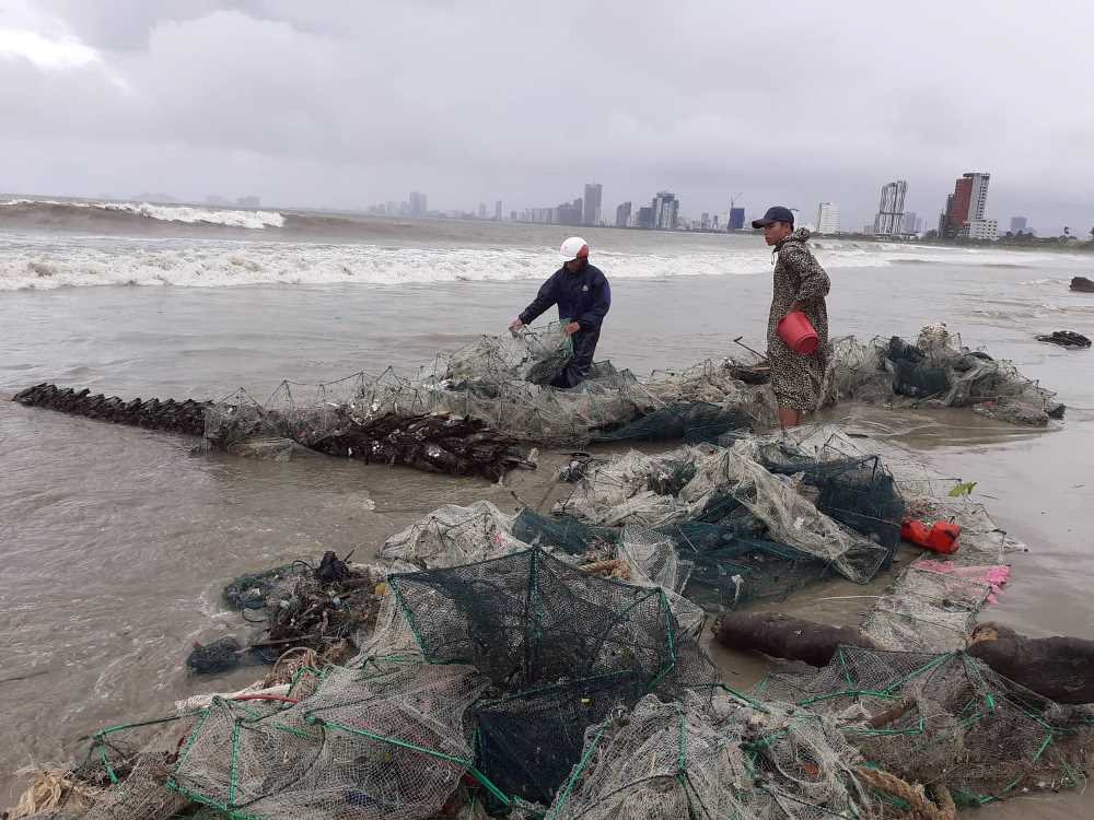 Ngư d&acirc;n thu gom ngư lưới cụ tr&ecirc;n thuyền th&uacute;ng bị ch&igrave;m. Ảnh TN&amp;MT