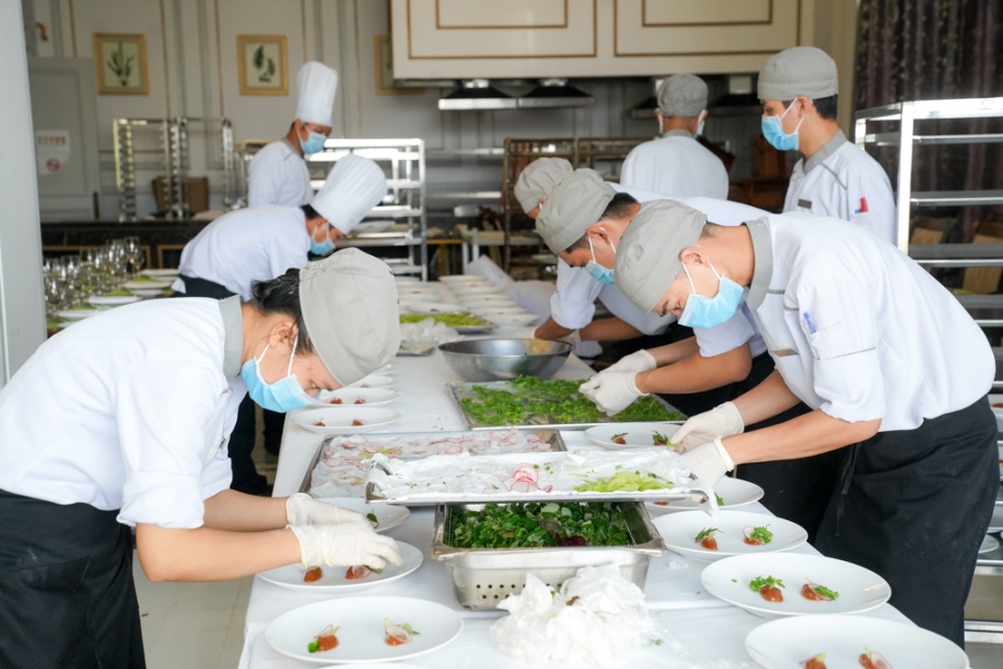 Sau giờ trưa, d&agrave;n nh&acirc;n vi&ecirc;n ưu t&uacute; trong nh&agrave; bếp của Vinpearl Ph&uacute; Quốc chuẩn bị những c&ocirc;ng đoạn cuối c&ugrave;ng một c&aacute;ch cẩn thận nhất cho 500 vị kh&aacute;ch trong đ&aacute;m cưới tổ chức v&agrave;o chiều tối ng&agrave;y 9/11.