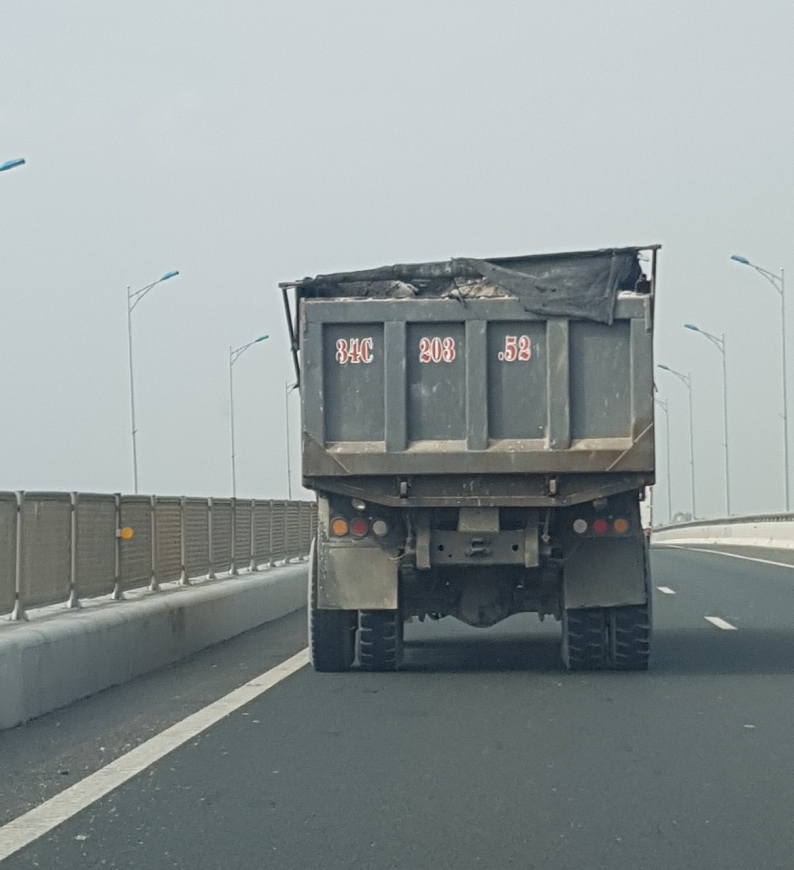 Xe chở đất chạy trên tuyến cao tốc Hạ Long - Hải Phòng, không được phủ bạt kín,  đất đá rơi xuống đường bất cứ lúc nào,  gây ảnh hưởng đến giao thông.