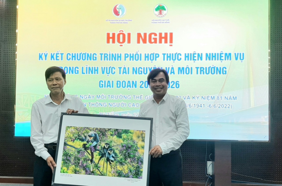 Lãnh đạo Sở TN&MT (phải) tặng tranh vooc chà vá chân nâu- “nữ hoàng” của các loài linh trưởng cho BĐD NCT thành phố