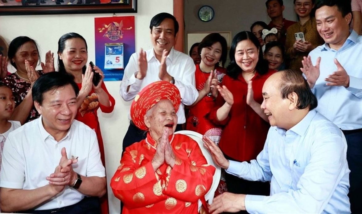 Chủ tịch nước Nguyễn Xuân Phúc thăm và tặng quà cụ Phạm Thị Lứu. Ảnh TTXVN