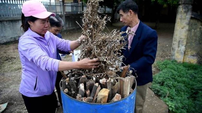 Thành viên CLB LTHTGN thôn Lầy, Phúc Thọ, xếp củi gỗ vào thùng phuy để làm than sinh học