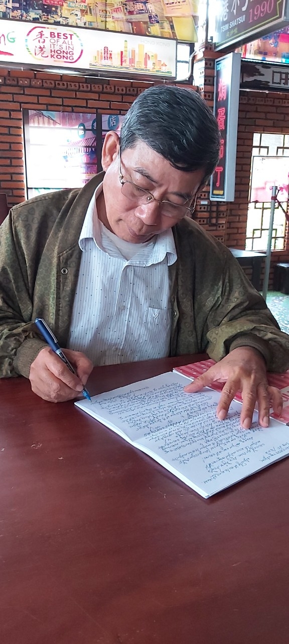 Ông Võ Văn Sung đang viết văn bản bằng chữ Khmer.