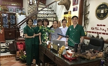 Chị Đỗ Thị Sinh thăm lại nhà thuốc chụp ảnh cùng với thầy Giang và các y bác sĩ tại nhà thuốc