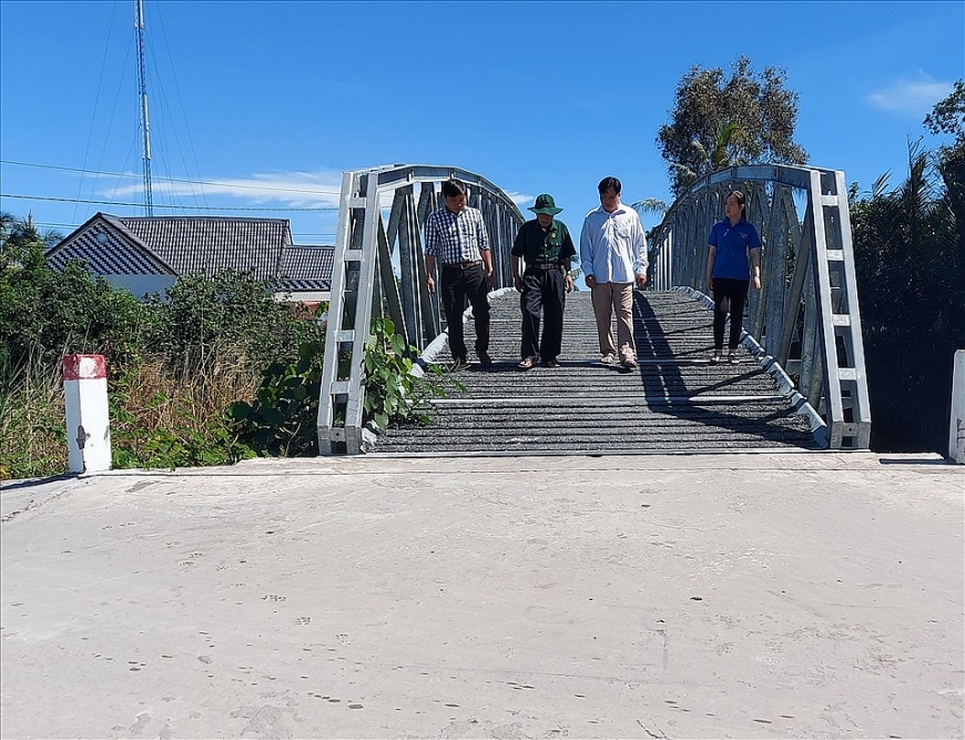 Cụ Lê Quang Núi (thứ 2 từ trái qua) cùng người dân trên cây cầu mà cụ vận động xây dựng.