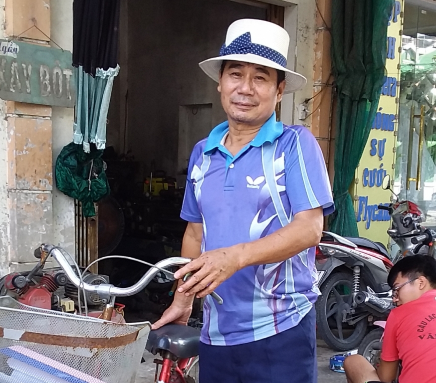 Ông Đoàn Quang Minh đạp xe đi cơ sở.