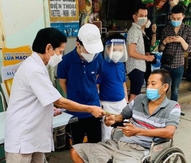 Ông Giảng phát tiền hỗ trợ cho những người lao động trong khu phố. Ảnh: NVCC.