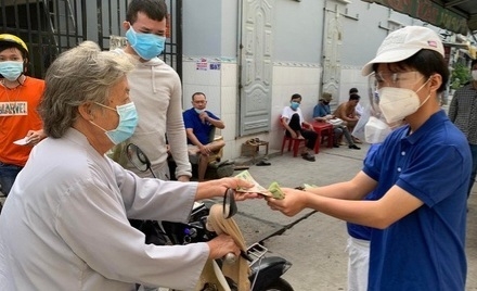 Gia đình ông Giảng phát tiền hỗ trợ cho NCT. Ảnh: NVCC.