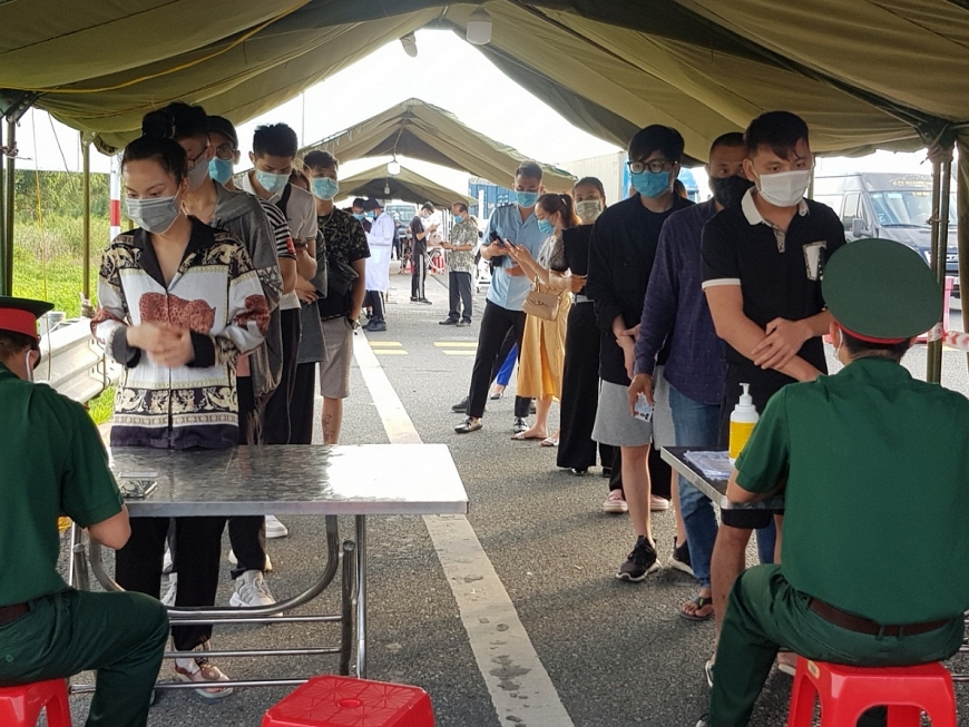 Để hạn chế lây lan dịch bệnh xâm nhập từ bên ngoài từ 0 giờ ngày 8/5 Quảng Ninh đã tái khởi động các chốt kiểm soát phòng chống dịch tại tất cả các cửa ngõ ra vào Quảng Ninh. Ảnh : Hướng dẫn khai báo y tế, kiểm tra người và phương tiện vào Quảng Ninh tại cầu Bạch Đằng.