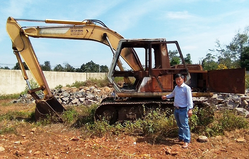 Ông Nguyễn Đình Lộc bên chiếc xe bị kẻ xấu đốt cháy, hủy hoại.