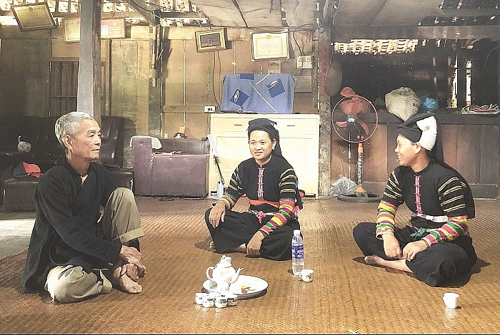 Ông Chi Viết Hải, Người có uy tín ở xóm Khuổi Khon, xã Kim Cúc, huyện Bảo Lạc, tỉnh Cao Bằng trao đổi việc giữ gìn bản sắc văn hóa dân tộc với đồng bào Lô Lô.