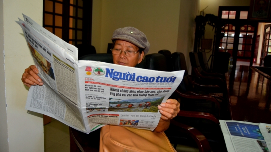 Bà Tâm đang xem báo.