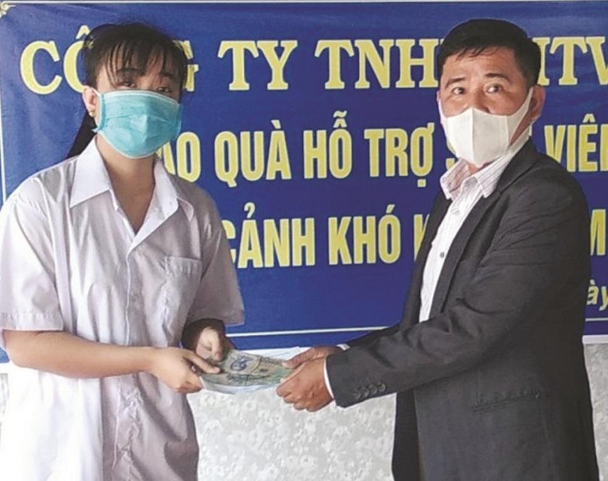 ông Nguyễn Văn Lắm trao học bổng cho em Huỳnh Thị Diệu có điều kiện vào đại học.