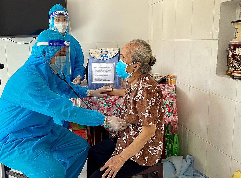 Cán bộ y tế kiểm tra sức khỏe người cao tuổi có bệnh lí nền tại Trạm Y tế lưu động. 