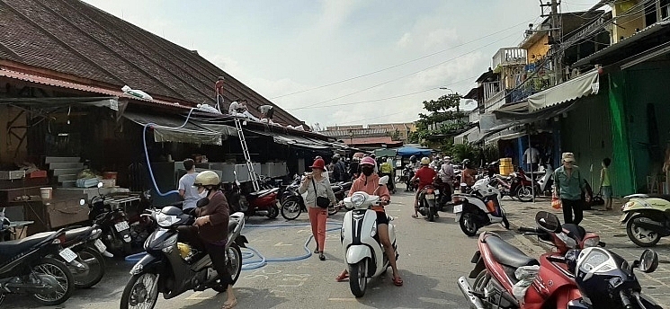 Công nhân Công ty cổ phần Công trình công cộng Hội An dọn quét bùn non trên đường Bạch Đằng 