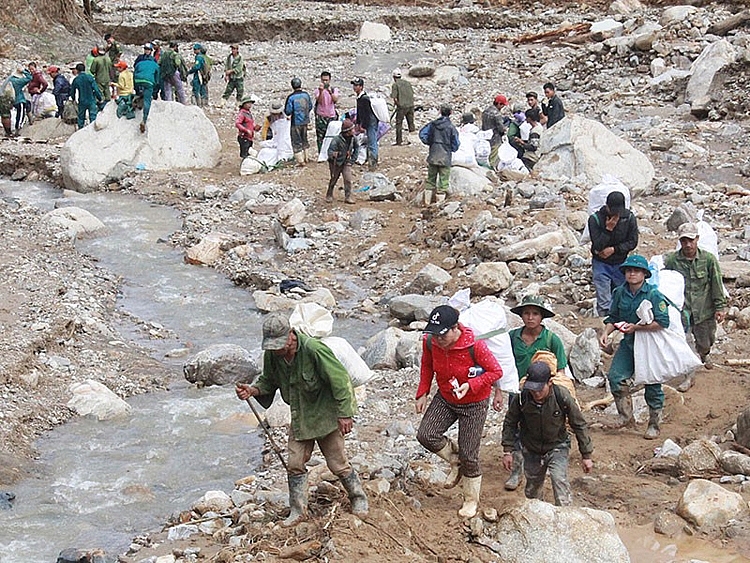 Người dân xã Phước Thành cắt rừng, cõng hàng cứu trợ.